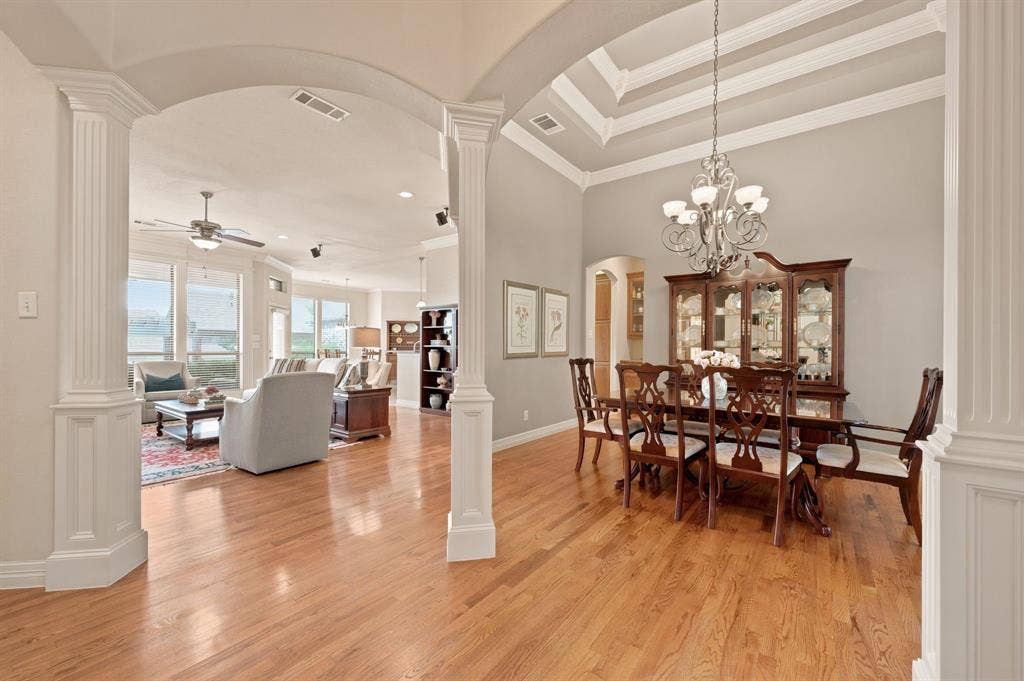 Dining area featuring wood-finish flooring, a coffered ceiling, and a decorative chandelier