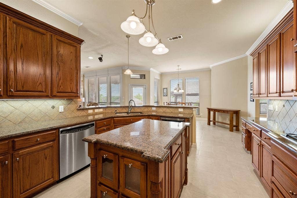 Kitchen featuring stained-wood cabinetry, stone-finish countertops, tile backsplash, a central island, and recessed lighting