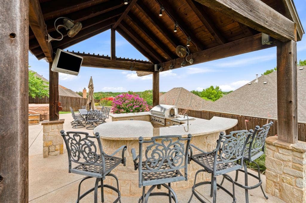 Expansive outdoor living area featuring a covered patio with a vaulted wood ceiling