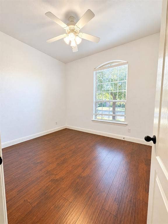 1731 Teakwood Drive, Wylie, TX 75098 Room featuring wood-finish flooring, an arched window, and a multi-light ceiling fan