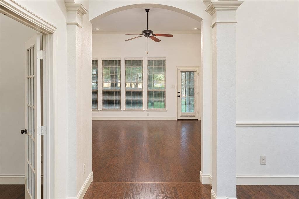 1731 Teakwood Drive, Wylie, TX 75098 Arched entryway featuring decorative columns, wood-finish flooring, multi-pane glass door, and a ceiling fan