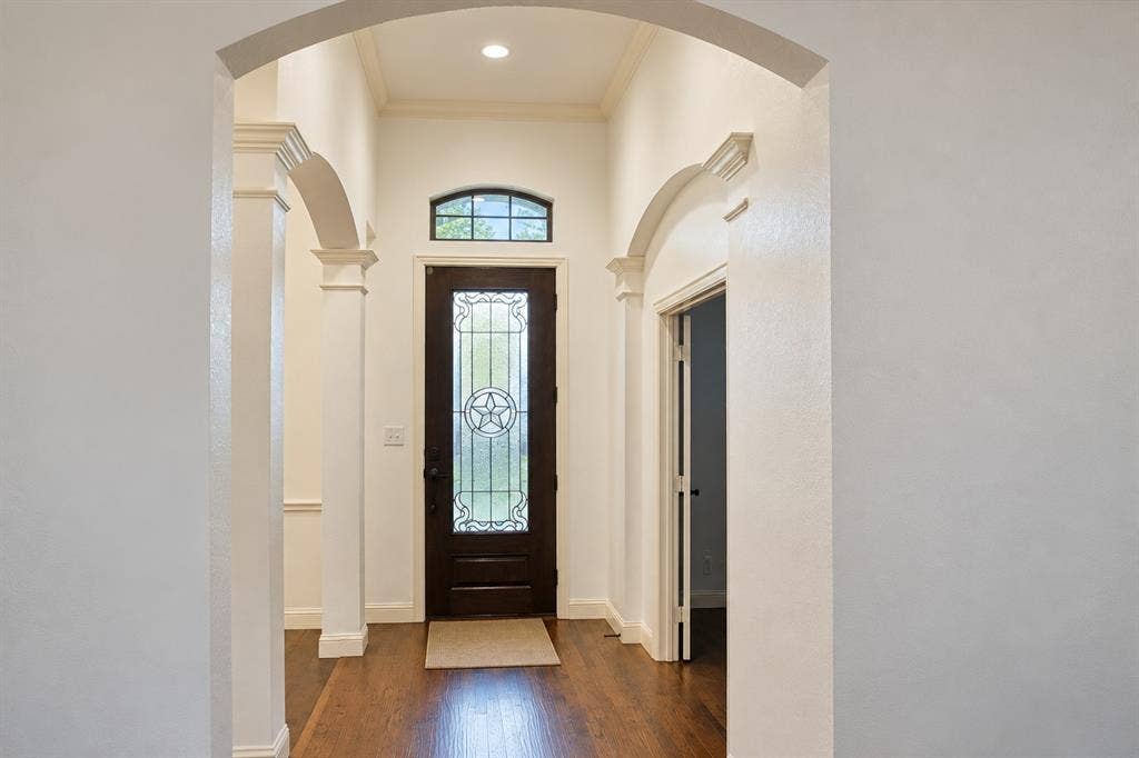 1731 Teakwood Drive, Wylie, TX 75098 Foyer featuring arched structural columns, wood-finish flooring, and recessed ceiling lighting