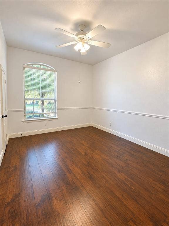 1731 Teakwood Drive, Wylie, TX 75098 Room featuring wood-finish flooring, white chair rail molding, an arched-top window, and a ceiling fan with integrated light fixture