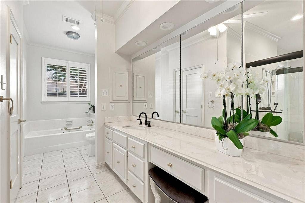 Dual bath area with generous counters, bathtub and shower.