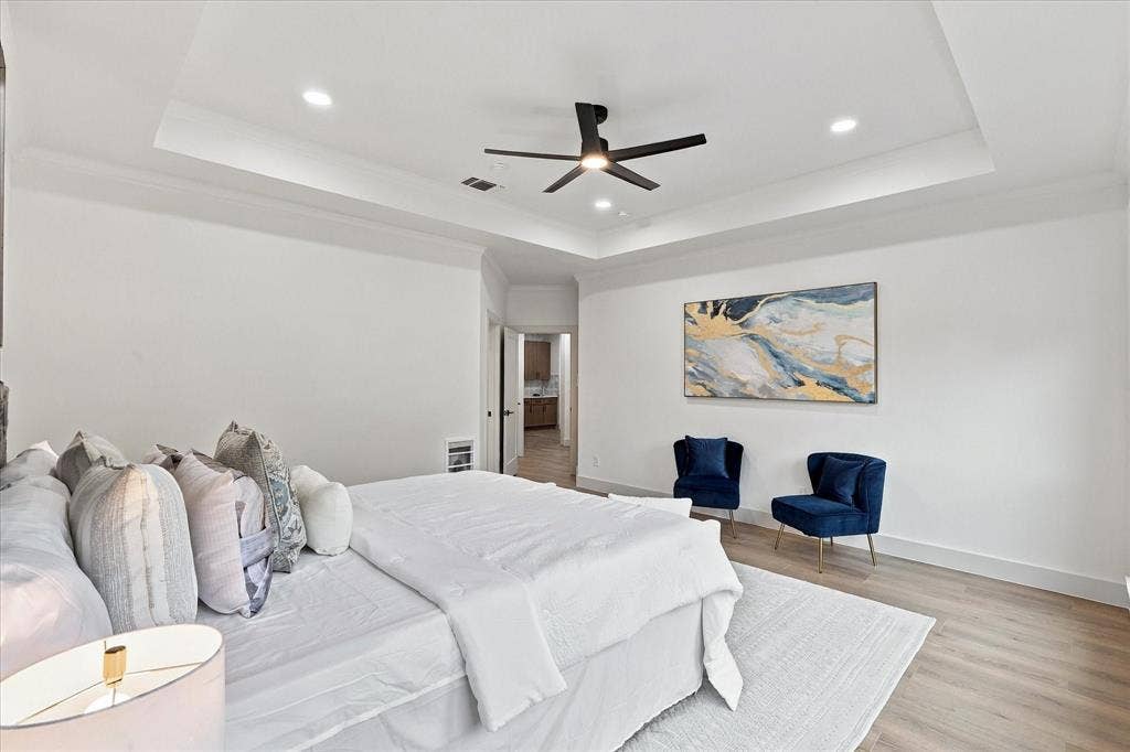 5609 Hillview Court, McKinney, TX 75072 Tray ceiling featuring recessed lighting and a central matte black ceiling fan, complemented by wood-finish flooring