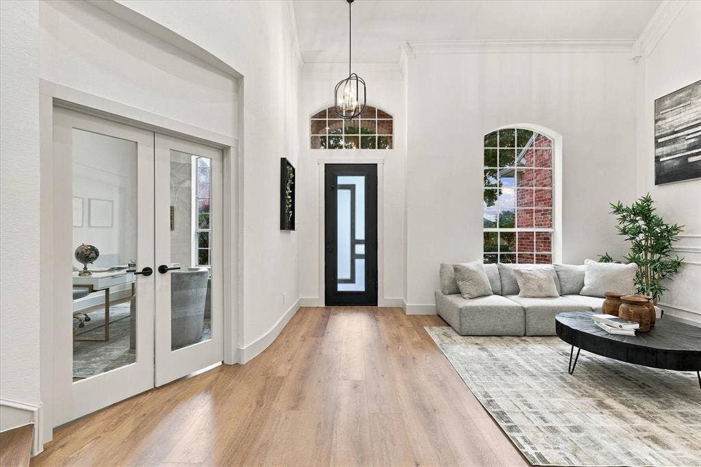 5609 Hillview Court, McKinney, TX 75072 Foyer featuring high ceilings, wood-finish flooring, a contemporary front door with geometric glass panels, arched window, and dual glass-panel French doors