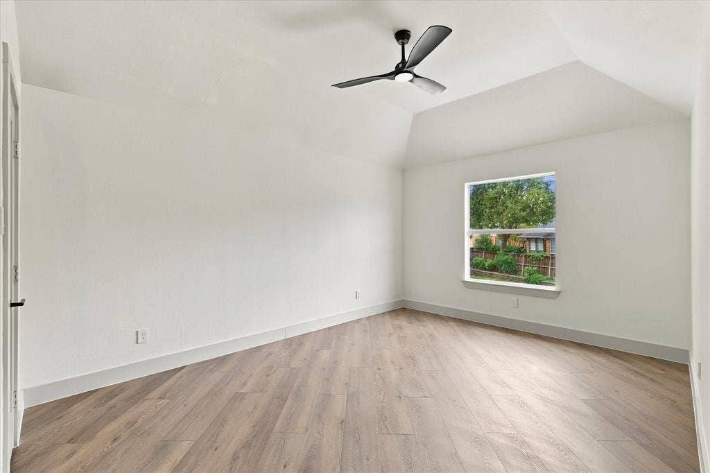 5609 Hillview Court, McKinney, TX 75072 Vaulted ceiling featuring a matte black three-blade ceiling fan and wood-finish flooring