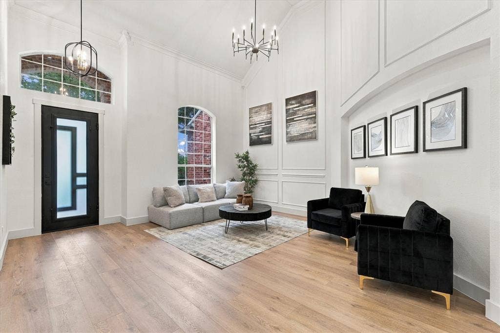 5609 Hillview Court, McKinney, TX 75072 Entryway featuring vaulted ceilings, wood-finish flooring, wainscoting detail, arched windows, and a black-framed glass front door