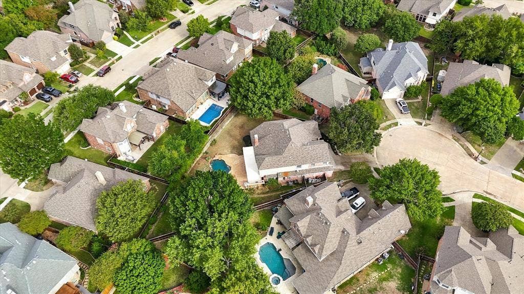 5609 Hillview Court, McKinney, TX 75072 Aerial perspective of a multi-story residence featuring a shingled roof, a backyard in-ground swimming pool, an attached garage, and mature tree landscaping