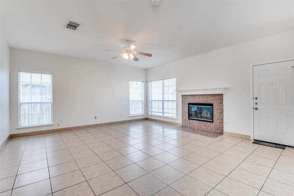 5329 Raven Row, Dallas, TX 75236 Unfurnished living room with light tile patterned flooring, a fireplace, and ceiling fan