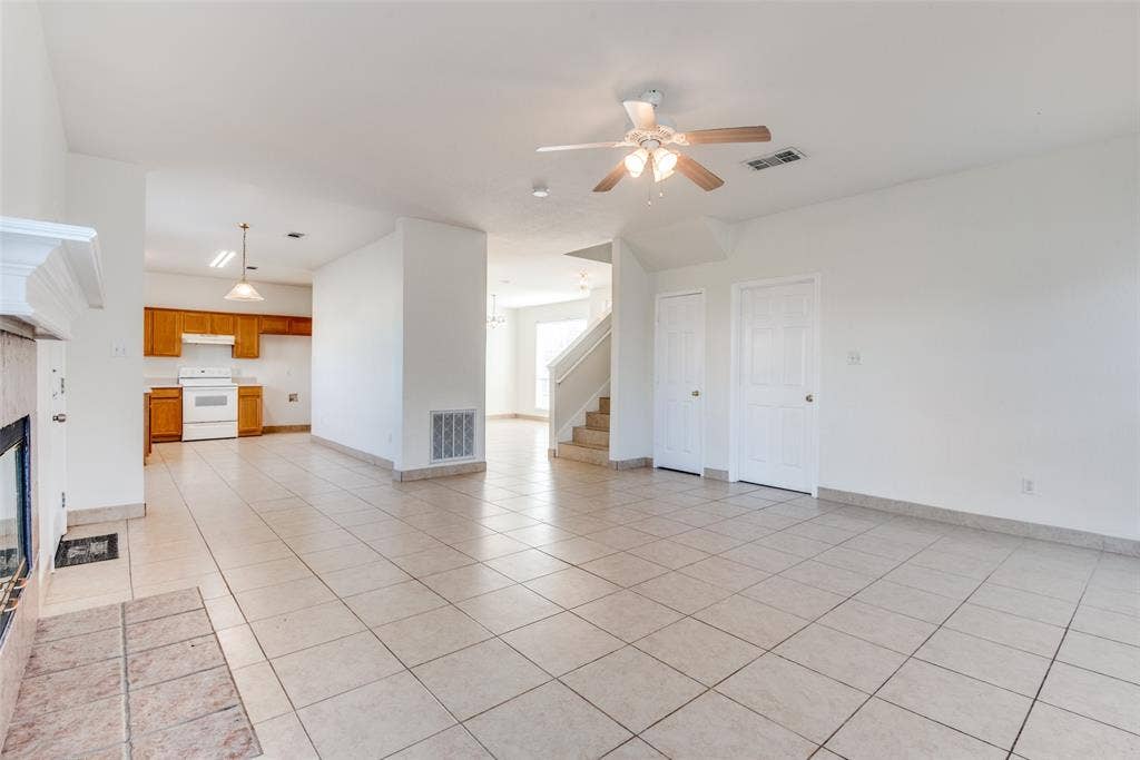 5329 Raven Row, Dallas, TX 75236 Unfurnished living room with light tile patterned flooring, a fireplace, and ceiling fan