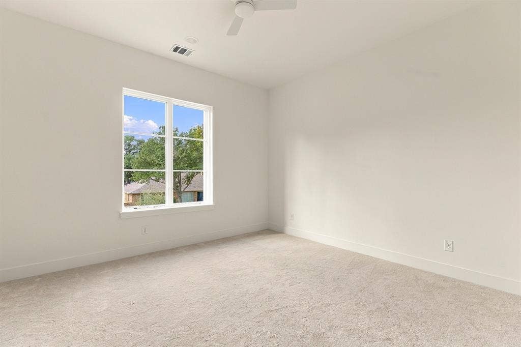 4953 Forest Bend Road, Dallas, TX 75244 Neutral-toned interior space featuring wall-to-wall carpeting, a multi-pane window, and a ceiling-mounted fan