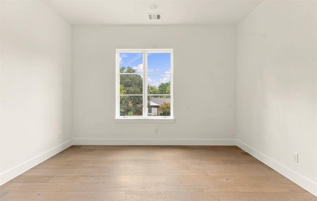 4953 Forest Bend Road, Dallas, TX 75244 Interior space featuring wood-finish flooring, white walls, and a multi-pane window with natural exterior exposure