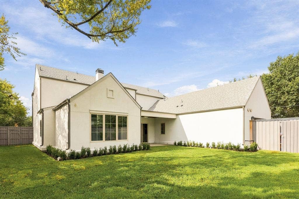 4953 Forest Bend Road, Dallas, TX 75244 Stucco exterior featuring a covered patio, shingle roof, multi-pane windows, and a fenced backyard