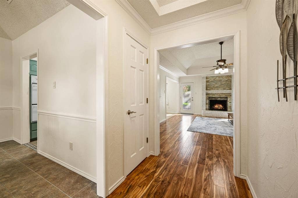 339 Park North Lane, Keller, TX 76248 Entryway featuring tile flooring, wood-finish flooring, tray ceilings, and a stacked-stone fireplace
