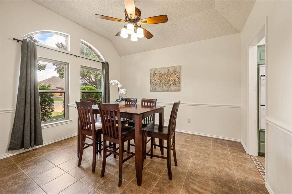 339 Park North Lane, Keller, TX 76248 Dining space featuring high vaulted ceilings, tiled flooring, chair rail molding, and arched windows