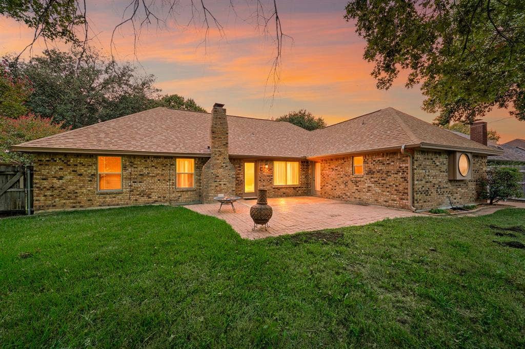 339 Park North Lane, Keller, TX 76248 Brick exterior featuring a masonry chimney, paved rear patio, composition shingle roof, and exterior circular window