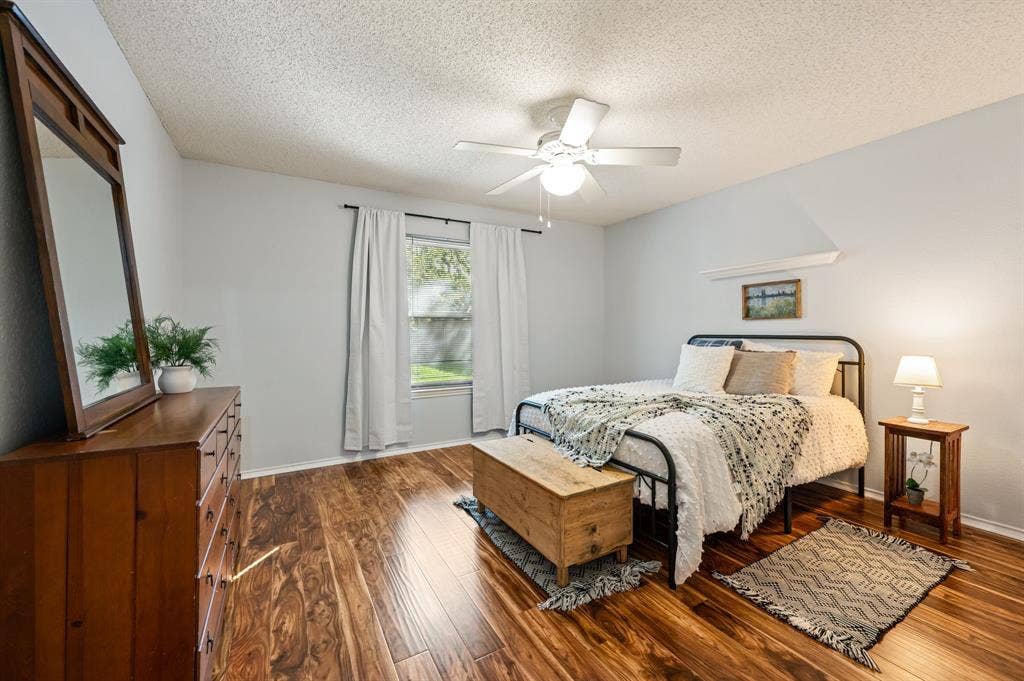 339 Park North Lane, Keller, TX 76248 Bedroom featuring wood-finish flooring, a central ceiling fan with an integrated light fixture, and a built-in wall shelf