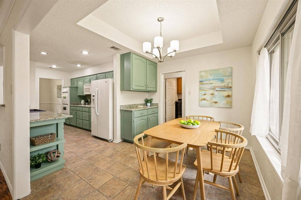 339 Park North Lane, Keller, TX 76248 Kitchen featuring green cabinetry, stone-finish countertops, recessed lighting, a tray ceiling, and tile flooring