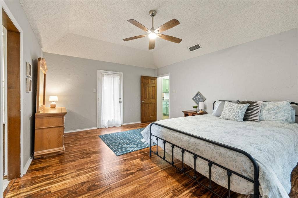 339 Park North Lane, Keller, TX 76248 Vaulted ceiling featuring a five-blade ceiling fan with integrated lighting, wood-finish flooring, and a glass-paneled exterior door