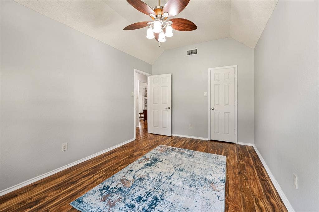 339 Park North Lane, Keller, TX 76248 Vaulted ceiling featuring a central five-blade light fixture, wood-finish flooring, and two six-panel interior doors