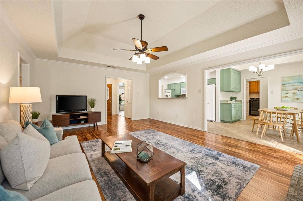 339 Park North Lane, Keller, TX 76248 Living area featuring tray ceilings, a ceiling fan with integrated lighting, and wood-finish flooring