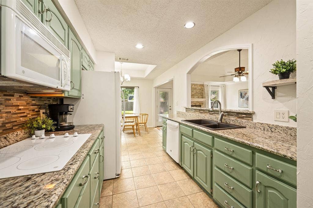 339 Park North Lane, Keller, TX 76248 Kitchen featuring sage green cabinetry, stone-patterned countertops, a tiled backsplash, a double-basin sink with a pull-down faucet, and recessed lighting