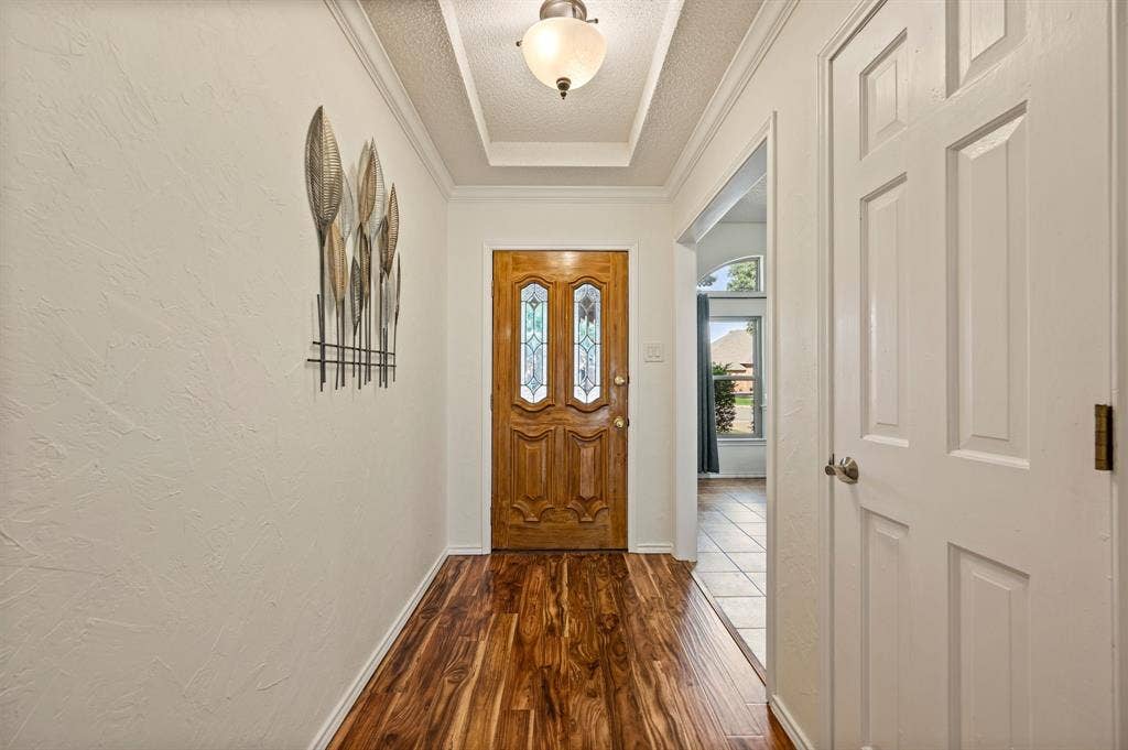 339 Park North Lane, Keller, TX 76248 Foyer featuring wood-finish flooring, a recessed tray ceiling, a central dome-style light fixture, and a solid wood front door with decorative glass inserts