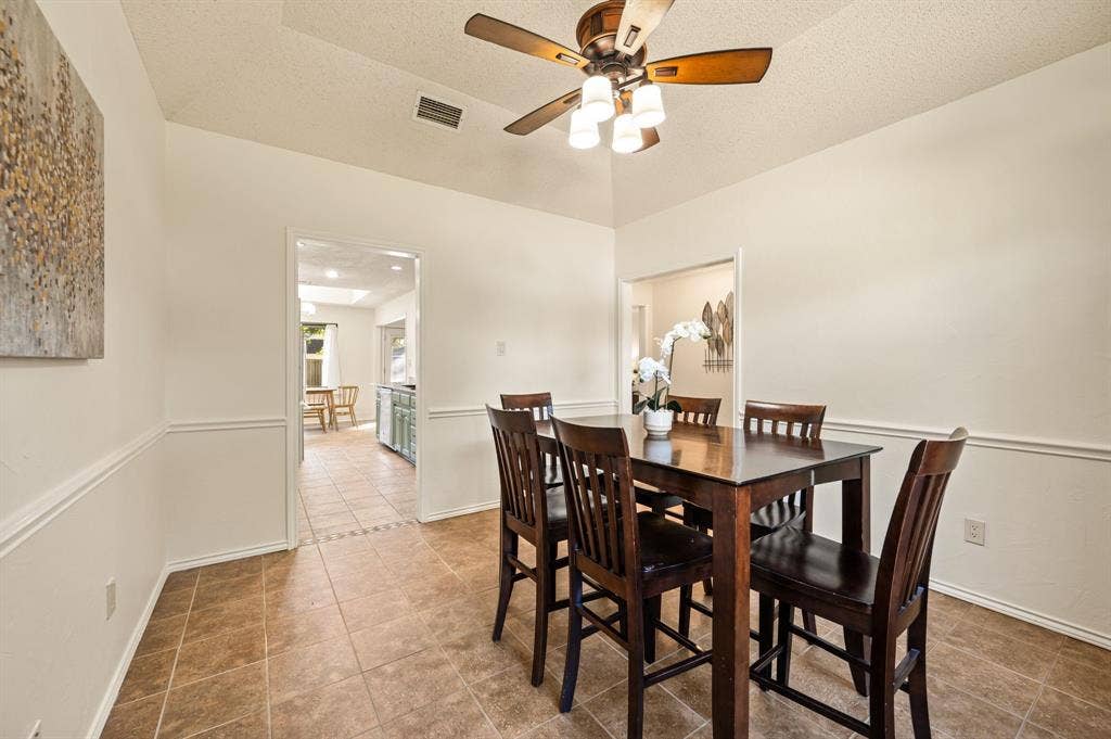 339 Park North Lane, Keller, TX 76248 Vaulted ceiling with a central multi-light ceiling fan and decorative chair rail molding