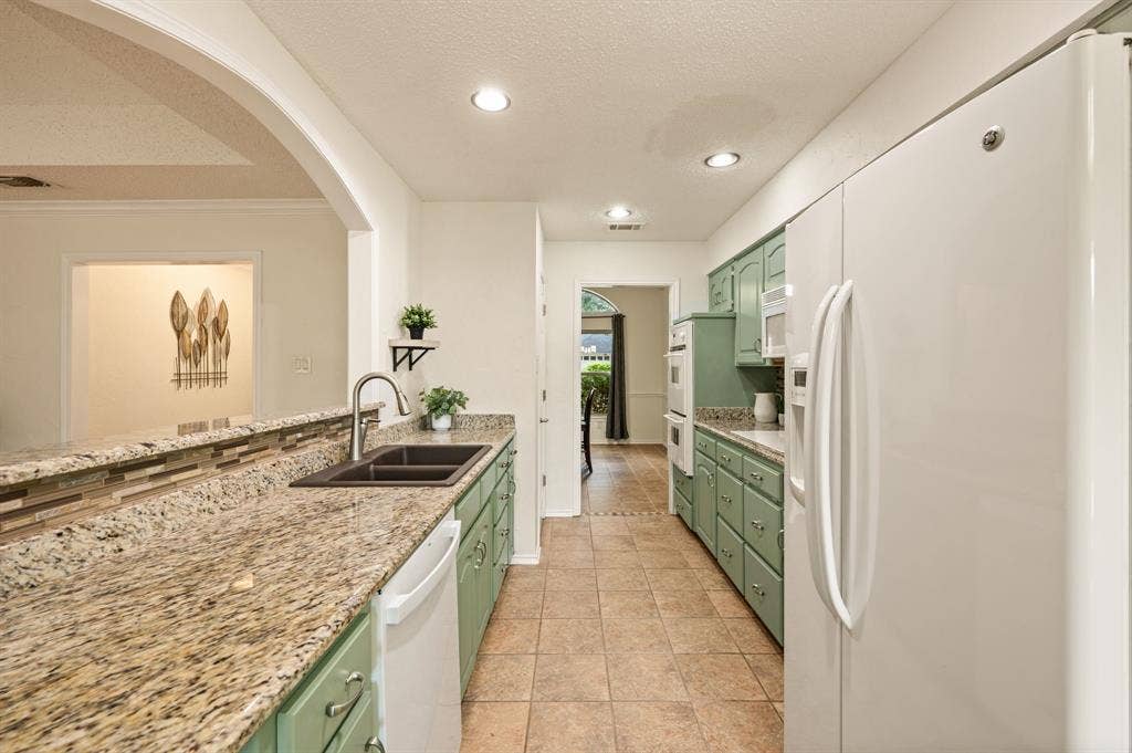 339 Park North Lane, Keller, TX 76248 Kitchen featuring stone-finish countertops, dual-basin undermount sink, ceramic tile flooring, recessed lighting, and built-in double wall ovens