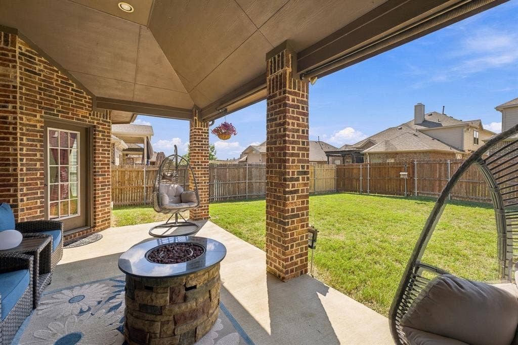 Covered patio with a concrete floor, brick exterior masonry, structural brick support columns, recessed ceiling lighting, and a fenced backyard
