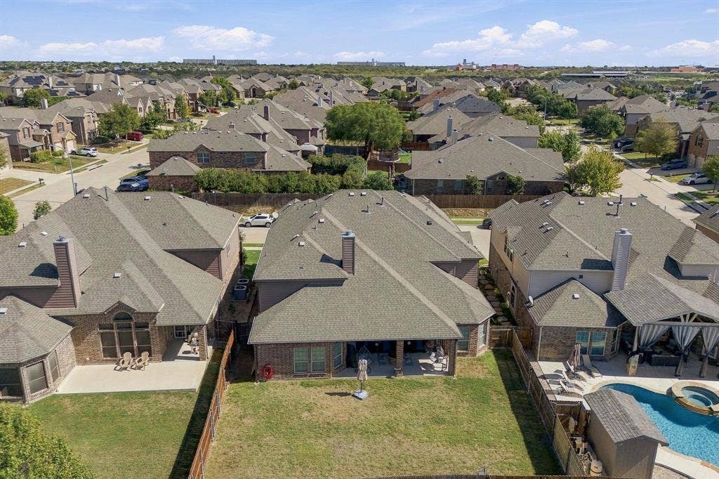 Brick veneer exterior, composition shingle roof, covered rear patio, and fenced perimeter