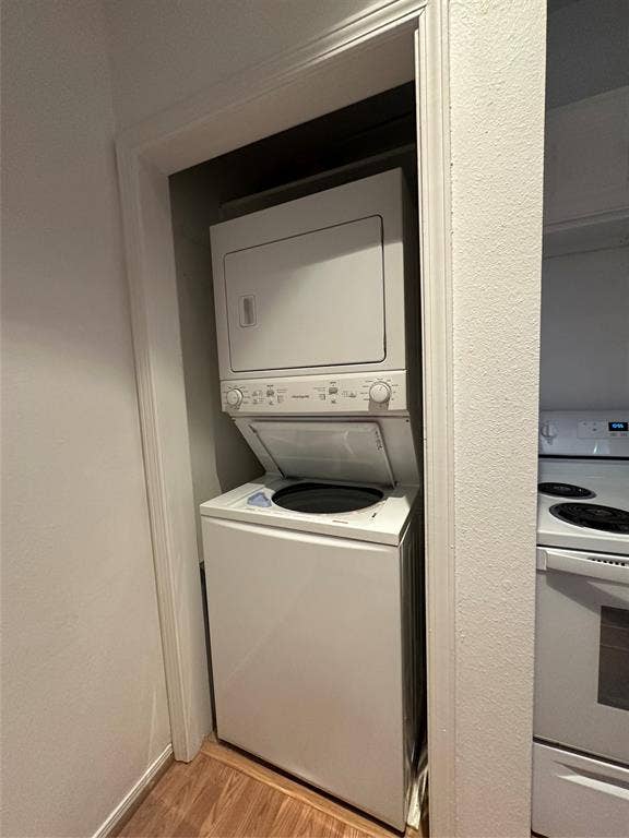 5757 E University Boulevard, #27p, Dallas, TX 75206 White stacked laundry center with top-load washer and electric dryer, recessed within a dedicated utility closet