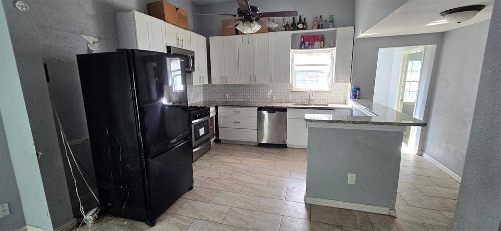 517 Clark Street, Garland, TX 75040 Kitchen featuring white cabinetry, stone-finish countertops, tiled backsplash, stainless steel appliances, and tile flooring