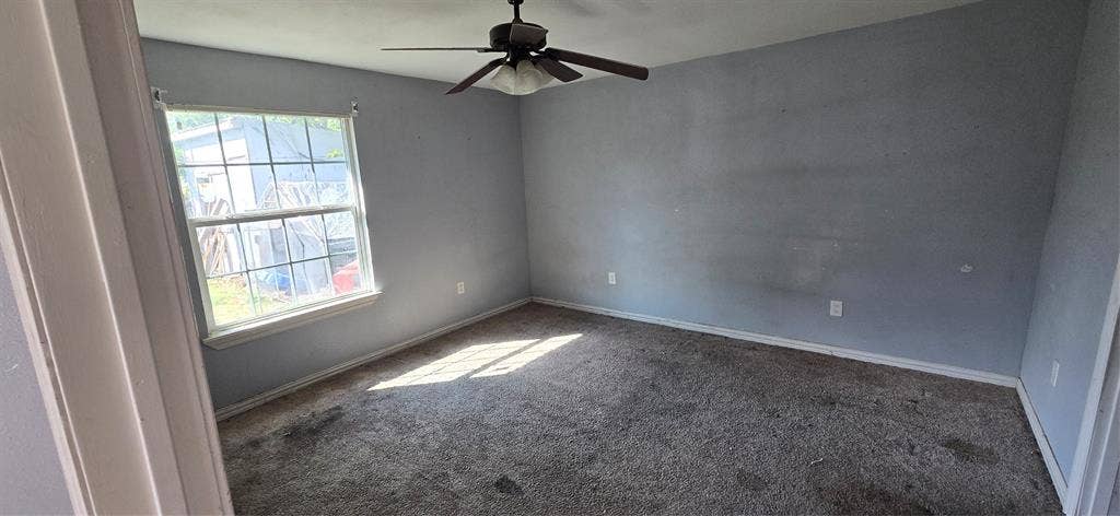 517 Clark Street, Garland, TX 75040 Room featuring neutral-toned walls, carpeting, and a multi-blade ceiling fan with an integrated light fixture, complemented by a single-hung window