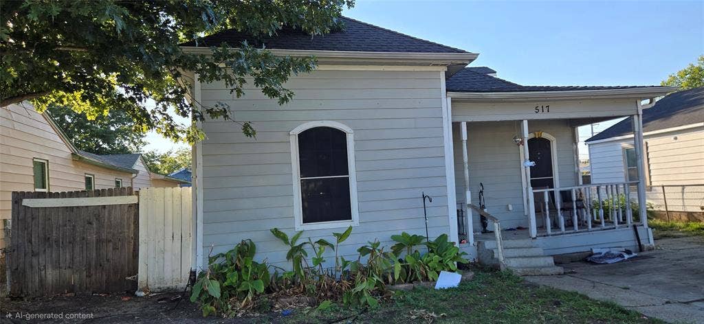 517 Clark Street, Garland, TX 75040 Single-story exterior featuring horizontal siding, a covered front porch with a railing, an arched window, and a gabled roof