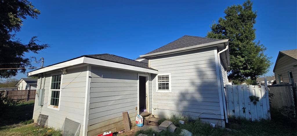 517 Clark Street, Garland, TX 75040 Exterior elevation featuring light-toned horizontal siding, a dark-toned shingle roof, white trim, and a multi-pane window