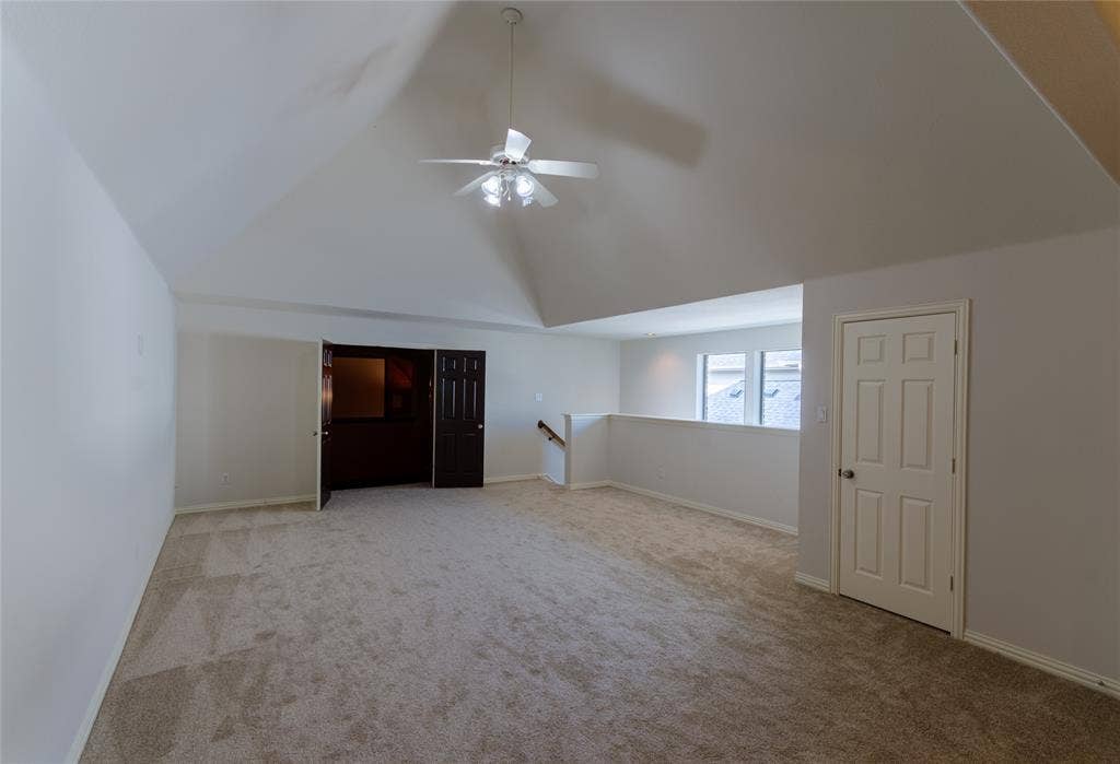 Game room Vaulted ceilings featuring a central overhead fan, neutral carpeting, and panel-style interior doors