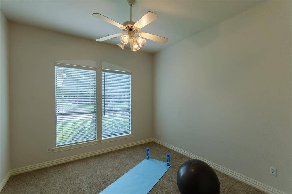 Bedoom featuring neutral wall tones, plush wall-to-wall carpeting, dual windows with arched top glass, and a central ceiling fan with multi-light fixture