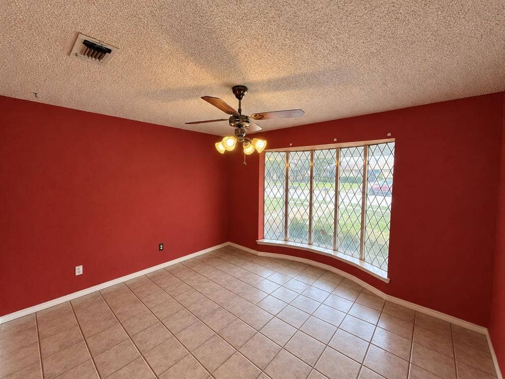 3408 Bellah Court, Irving, TX 75062 Bay window with diamond-patterned muntins, ceramic tile flooring, and a ceiling fan with integrated lighting