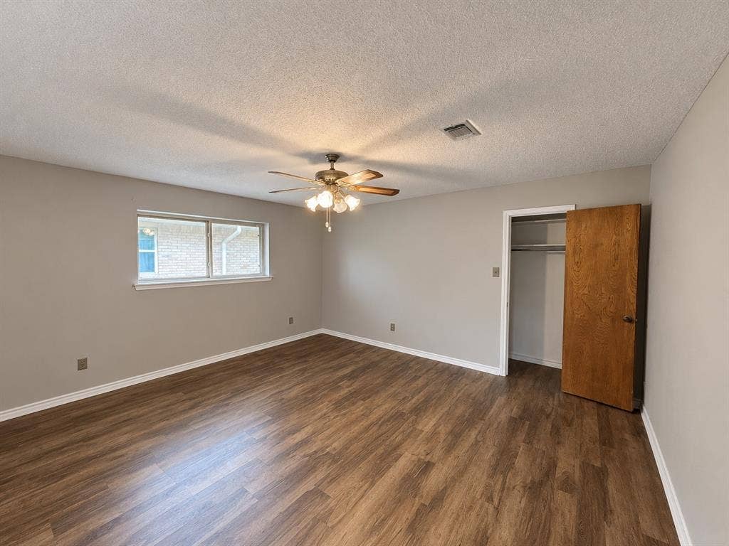3408 Bellah Court, Irving, TX 75062 Interior room featuring wood-finish flooring, neutral wall paint, a ceiling fan with integrated lighting, and a closet with a wooden door