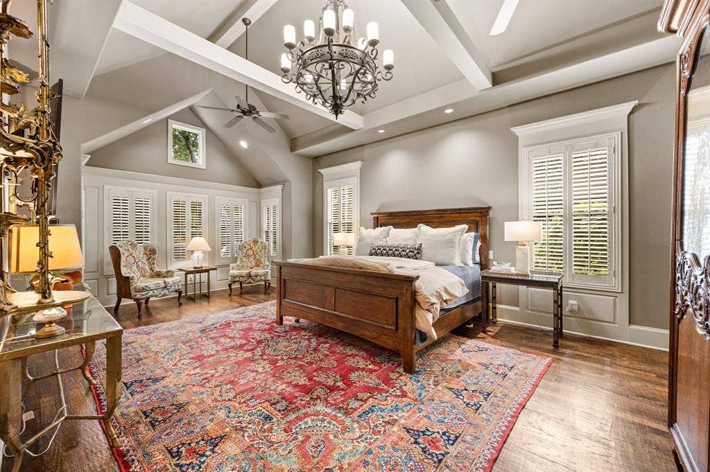 The spacious primary suite offers a luxurious private retreat, complete with a comfortable sitting area, elegant plantation shutters, separate his-and-hers closets, and an oversized ensuite bath designed for relaxation and comfort.