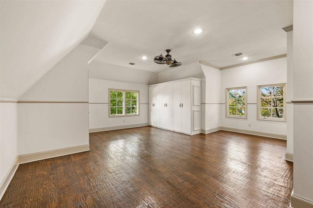 This spacious fifth bedroom offers exceptional versatility, featuring a Jack-and-Jill-style bath, walk-in closet, additional built-in cabinetry for storage, and a dedicated sitting area ideal for a desk or gaming space. Its generous size and flexible layout make it perfect for a bedroom, home office, or multipurpose retreat.