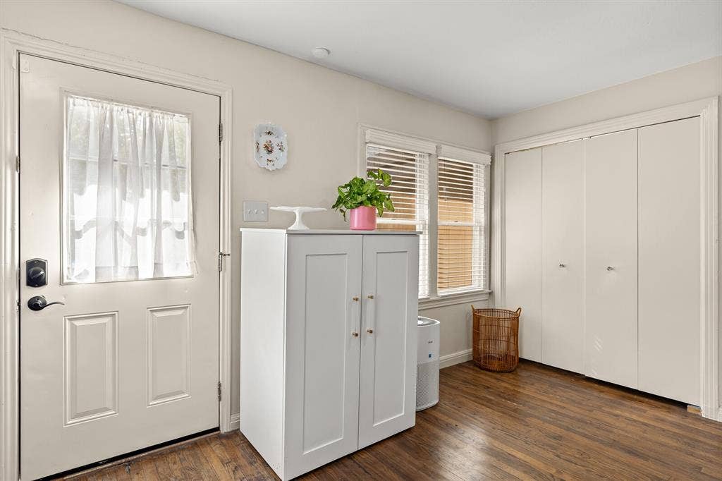 2425 S 2nd Street, Waco, TX 76706 Neutral-toned interior featuring wood-finish flooring, bi-fold closet doors, and multi-pane windows with horizontal blinds
