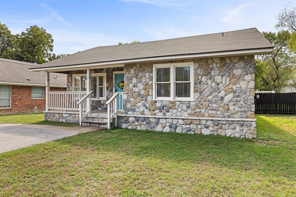 2425 S 2nd Street, Waco, TX 76706 Stone veneer exterior featuring a covered front porch with white railing, asphalt shingle roof, and multi-pane windows