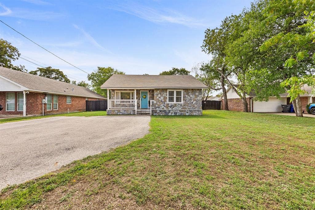 2425 S 2nd Street, Waco, TX 76706 Exterior facade featuring stone veneer, a covered front porch with white railing, and an expansive front lawn