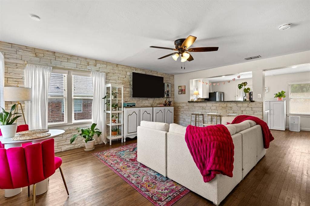 2425 S 2nd Street, Waco, TX 76706 Living area featuring stacked stone accent wall, wood-finish flooring, ceiling fan, and pass-through opening