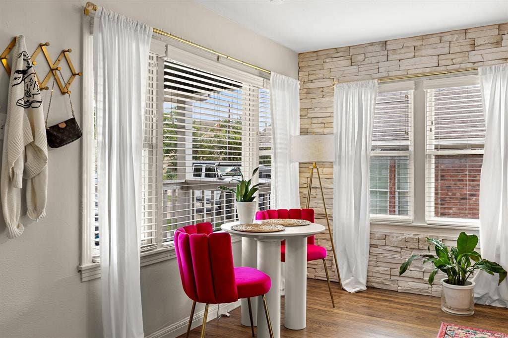 2425 S 2nd Street, Waco, TX 76706 Stacked stone accent wall with wood-finish flooring and multiple windows featuring horizontal blinds