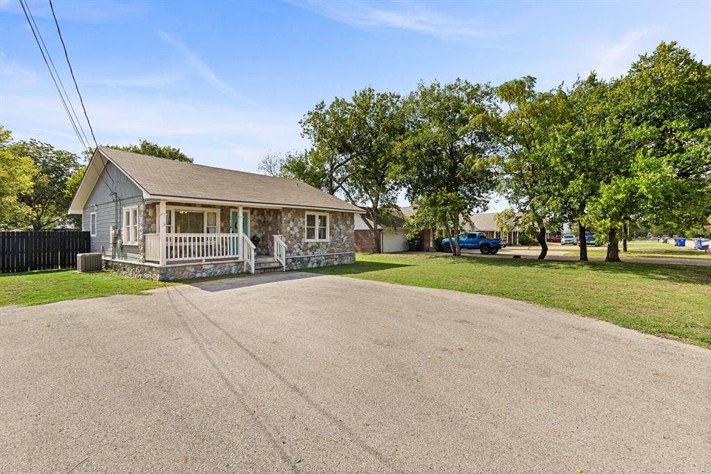 2425 S 2nd Street, Waco, TX 76706 Exterior facade featuring stone veneer siding, horizontal lap siding, a covered front porch with white railing, and an asphalt-paved driveway