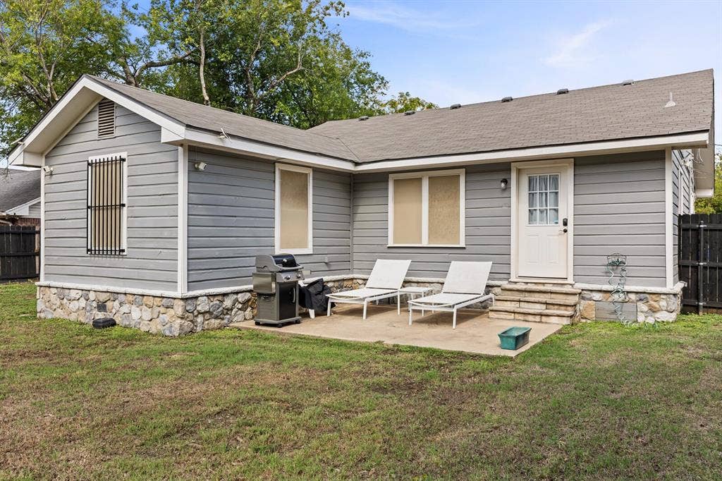 2425 S 2nd Street, Waco, TX 76706 Exterior featuring grey horizontal siding, stone veneer foundation accents, concrete patio, and a privacy fence